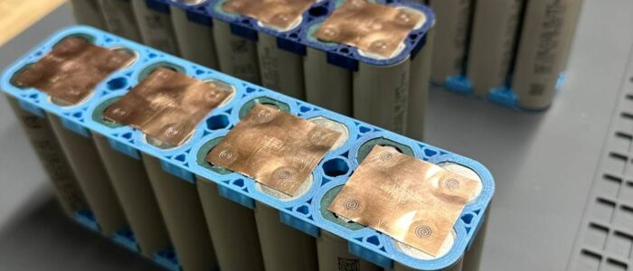 Welded copper busbars on cells in a holder