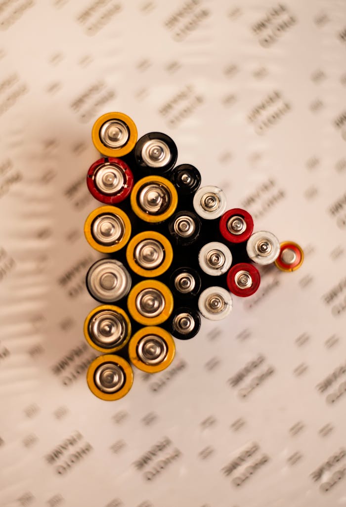 Crafting Captivating Headlines: Your awesome post title goes here Top view of assorted batteries in an artistic arrangement on a printed surface.